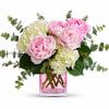 Pink peonies and white hydrangeas in a pink glass vase
