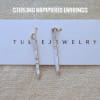 Pair of hammered silver drop earrings on a jewelry card