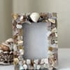 Decorative photo frame covered in shell pieces