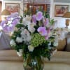 Large bouquet of pink and white orchids in a clear glass vase