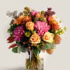 Bouquet of pink and peach flowers in a clear glass vase