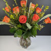 Orange roses arranged in a clear glass vase