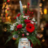 Christmas arrangement in a Santa-face mug with red flowers and pinecones