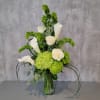 Green hydrangeas and white calla lilies in a glass vase