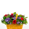 Mixed bouquet in a woven basket with red and purple flowers