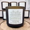 Black jar candle labeled "The Potting Shed" on a wooden tray