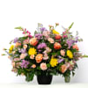 Soft pastel blooms create a gentle and comforting tribute, offering a sense