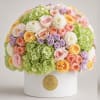 Round bouquet of pastel roses, hydrangeas, and white blooms in a white box