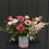 Mixed pink and peach roses in a two-tone ceramic vase