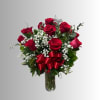Bouquet of red roses with baby's breath in a glass vase and red ribbon