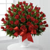 Large bouquet of red roses in a white vase with a red ribbon