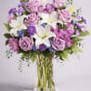 Bouquet of lavender roses and white lilies in a clear glass vase