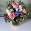 Pink roses and purple flowers arranged in a metallic vase