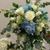 Bouquet of white roses and blue hydrangeas with mixed greenery