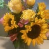 Bouquet of yellow roses and sunflowers in a glass vase