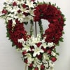 Heart-shaped standing spray of red roses and white lilies on an easel