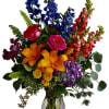 Colorful bouquet of roses, lilies, and mixed blooms in a glass vase