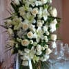 Large white floral standing spray on an easel with ribbon