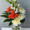 Orange roses and white chrysanthemums in a glass vase