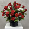 Red roses and carnations arranged in a black box
