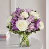 Bouquet of white and purple flowers in a clear glass vase