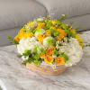 Yellow and white flower arrangement in a woven basket