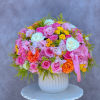 Large bouquet of pink, white, yellow, and orange roses in a white vase