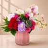 Pink vase arrangement with orchids, roses, carnations, and succulents