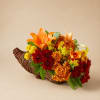Orange and red floral arrangement in a wicker cornucopia basket