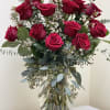 Bouquet of red roses with white filler flowers in a clear glass vase