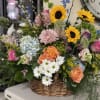 Mixed flower basket with sunflowers, roses, daisies, and hydrangeas