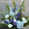 Basket arrangement of blue and white flowers with roses and hydrangeas