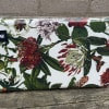 A cheerful fabric pouch patterned in bold red, pink and green botanicals