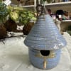 A charming glazed ceramic birdhouse in mottled blue makes a playful and