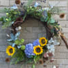 Floral wreath with sunflowers and blue hydrangeas on a twig base