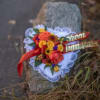 Heart-shaped floral tribute with red and yellow roses and a red ribbon
