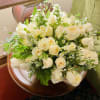 Bouquet of white roses with small white filler flowers and greenery