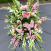 Large pink and white floral standing spray on an easel