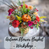 Autumn flower basket with mixed blooms and a small pumpkin in a basket