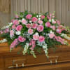 A graceful and feminine casket spray featuring a lush blend of soft