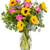 Bouquet of pink roses and yellow sunflowers in a clear glass vase