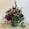 The 3-sided floral arrangement is arranged in a decorative metal container adorned