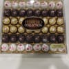 A gleaming assortment of Ferrero Rocher chocolates presented in a clear plastic