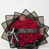 Bouquet of red roses wrapped in black paper with a ribbon and pearl accents