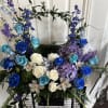 Blue, white, and purple floral arrangement with roses and orchids