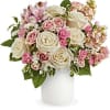 Pink and white roses arranged in a white vase