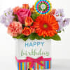 Birthday flower arrangement in a decorated gift box with a colorful topper