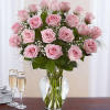 Pink roses arranged in a clear glass vase with baby's breath