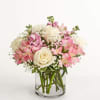 Pink and white bouquet of roses and lilies in a clear glass vase