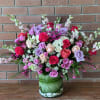 Mixed pink, lavender, and white roses in a glass vase